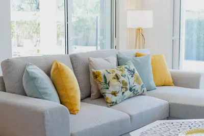 a couch with pillows on it in a living room at Villa Juliet in Boliqueime