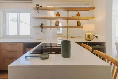 a kitchen with a white counter top and wooden cabinets at Villa Juliet in Boliqueime