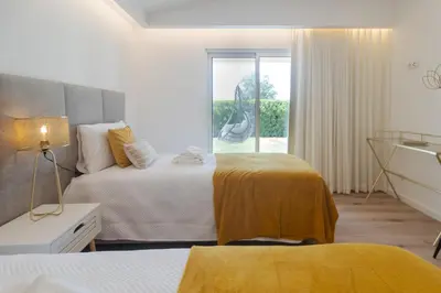 a hotel room with two beds and a window at Villa Juliet in Boliqueime