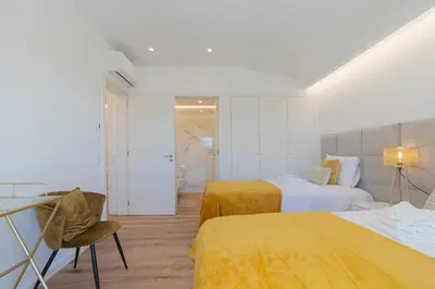 a hotel room with two beds and a chair at Villa Juliet in Boliqueime