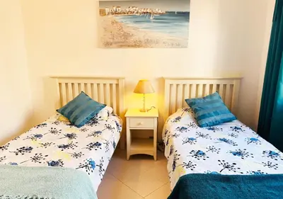 a bedroom with a large bed and white walls at Windmill Hill Apartment in Albufeira