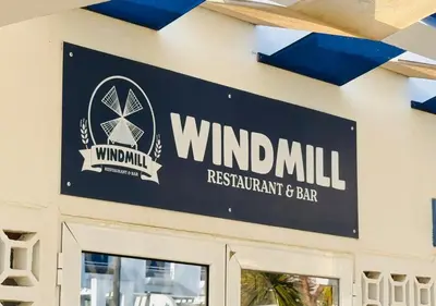 a sign for windmill restaurant and bar on the side of a building at Windmill Hill Apartment in Albufeira