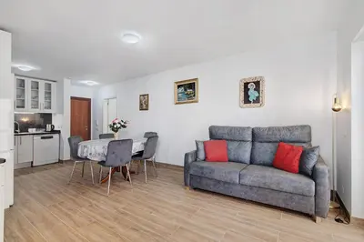 a kitchen and a dining room with a table and chairs at Sol e Mar Quarteira in Quarteira