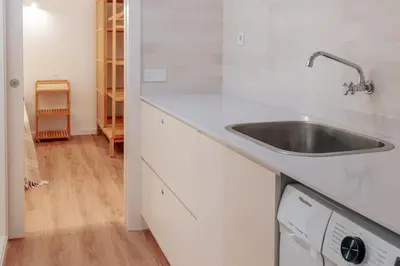a kitchen with a sink and wooden cabinets at Olhos de Agua Beach Villa by Mycelia in Olhos de Água