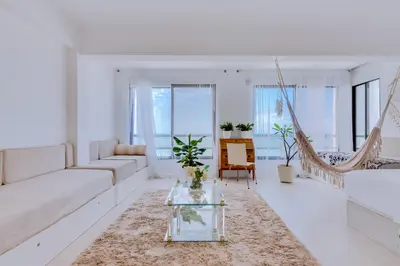a white living room with a couch and a table at Carteia Beachfront at Praia da Gaivota in Quarteira