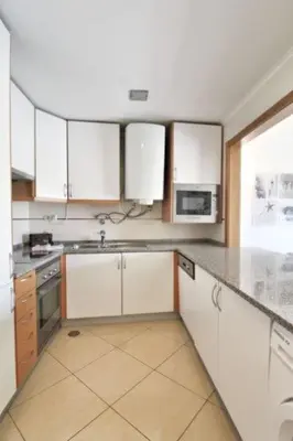 a kitchen with white cabinets and a counter top at Boa Vista Apartment with Sea Views and Shared Pool in Albufeira