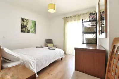 a bedroom with a white bed and a window at Boa Vista Apartment with Sea Views and Shared Pool in Albufeira