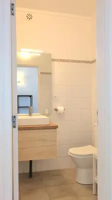 a white bathroom with a sink and a toilet at Peaceful Albufeira lodging in Albufeira