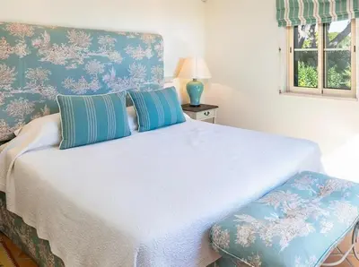 a bedroom with a white bed with a blue wall at Traditional property with pool nice large garden in FAO