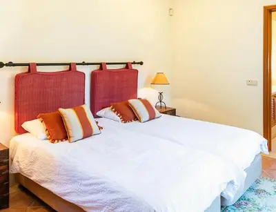 a bedroom with a white bed with two pillows at Traditional property with pool nice large garden in FAO