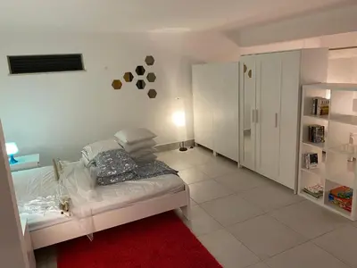 a white room with a bed and a red rug at Algarve Family Escape in Olhos de Água