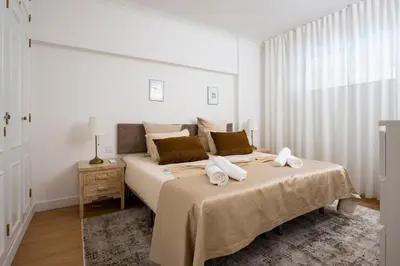 a white bedroom with a large bed with towels on it at Vilamoura Marine Prestige in Quarteira