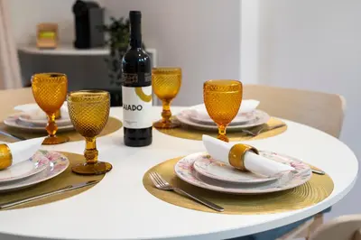 a table with plates and glasses and a bottle of wine at Vilamoura Marine Prestige in Quarteira