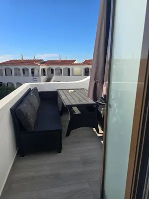 a balcony with a couch and a table on a roof at O Forte by MTPhomes in Albufeira