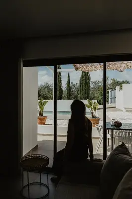 a woman sitting on a couch looking out of a window at Luzico ALGARVE in Loulé