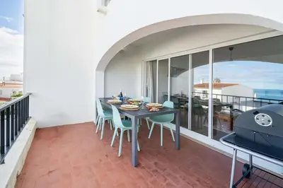 a dining room with a table and chairs on a balcony at Panoramic Sea Views & Balcony BBQ by HostWise in Albufeira