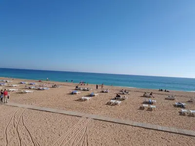 a beach with a lot of chairs and people at Top Strip Albufeira in Albufeira