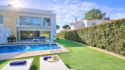 a backyard with a swimming pool and lawn at Villa Barinel by Cleverdetails located in a quiet and privileged area of Vilamoura in Quarteira