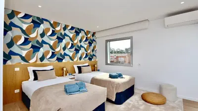 two beds in a room with a mural on the wall at Villa Barinel by Cleverdetails located in a quiet and privileged area of Vilamoura in Quarteira