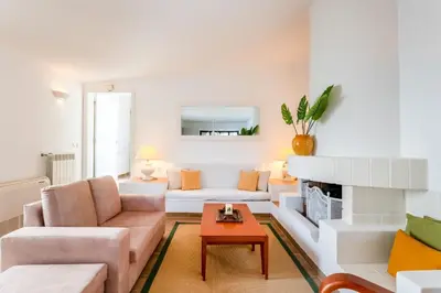 a living room with a couch and a fireplace at Villa Ipanema Poolside Living by LovelyStay in Quarteira