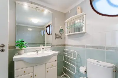 a bathroom with a sink and a toilet and a mirror at Villa Ipanema Poolside Living by LovelyStay in Quarteira