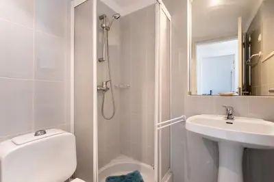a white bathroom with a shower and a sink at Villa Ipanema Poolside Living by LovelyStay in Quarteira