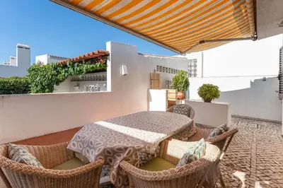 a patio with a table and wicker chairs at Villa Ipanema Poolside Living by LovelyStay in Quarteira