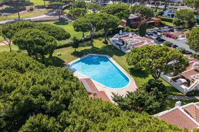 an aerial view of a pool with trees and houses at Villa Ipanema Poolside Living by LovelyStay in Quarteira