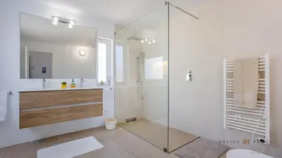 a bathroom with a glass shower and a sink at Greice Homes - Villa Carob Tree in Almancil