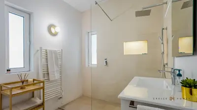 a white bathroom with a sink and a shower at Greice Homes - Villa Carob Tree in Almancil