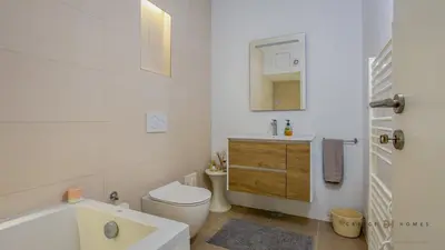 a bathroom with a tub and a toilet and a sink at Greice Homes - Villa Carob Tree in Almancil