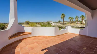 a balcony with a view of the ocean and palm trees at Greice Homes - Villa Carob Tree in Almancil