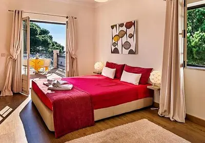 a bedroom with a red bed and a window at Stunning home with nice pool in Albufeira