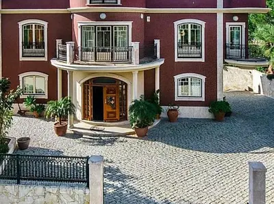 a large red building with potted plants in front of it at Stunning home with nice pool in Albufeira