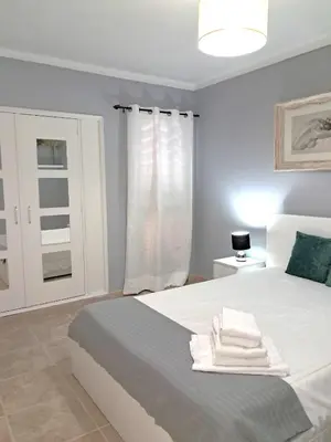 a bedroom with a white bed with towels on it at T1 Perto Marina Praia Vilamoura in Vilamoura