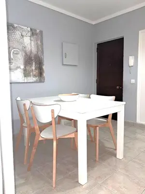 a white dining room table with chairs and a white table at T1 Perto Marina Praia Vilamoura in Vilamoura