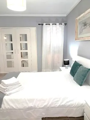 a bedroom with a large white bed and a window at T1 Perto Marina Praia Vilamoura in Vilamoura