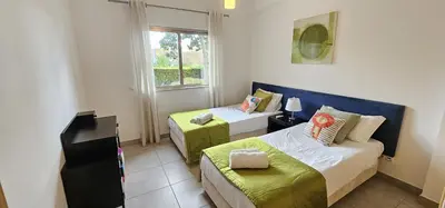 a small bedroom with two beds and a window at Vitismar II com piscina, jardim e garagem in Guia