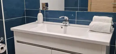 a white sink in a bathroom with blue tiles at Vitismar II com piscina, jardim e garagem in Guia