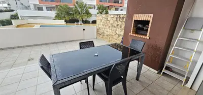 a black table and chairs on a balcony at Vitismar II com piscina, jardim e garagem in Guia