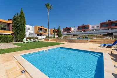 a swimming pool in front of a building at Vitismar II com piscina, jardim e garagem in Guia