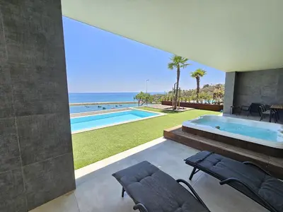 a house with a swimming pool and a view of the ocean at Finisterra Deluxe in Albufeira