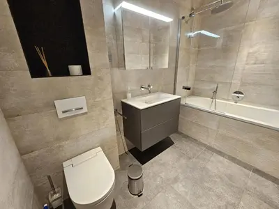 a bathroom with a toilet and a sink and a tub at Finisterra Deluxe in Albufeira