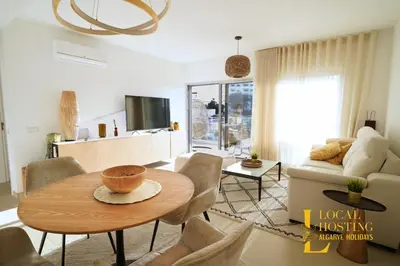 a living room with a table and a couch at Flat Green Garden by Localhosting in Albufeira