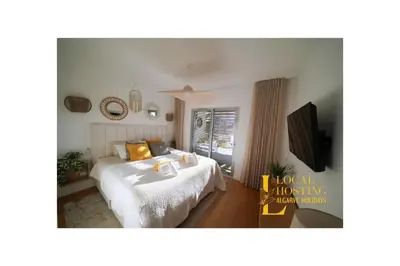 a bedroom with a bed and a tv in it at Flat Green Garden by Localhosting in Albufeira