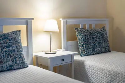 a bedroom with two beds and a table with a lamp at Apartamento Norte by Férias com Sol in Quarteira