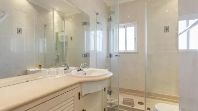 a bathroom with a sink and a glass shower at Greice Homes - Villa Vieira in Quarteira