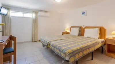 a bedroom with a bed and a desk and a window at Greice Homes - Villa Vieira in Quarteira