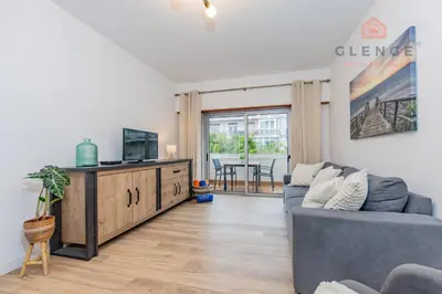 a living room with a couch and a tv at Torre Mira Praia 2 Quartos by Glenge Holiday in Loulé