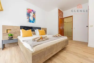 a bedroom with a large bed with yellow pillows at Torre Mira Praia 2 Quartos by Glenge Holiday in Loulé
